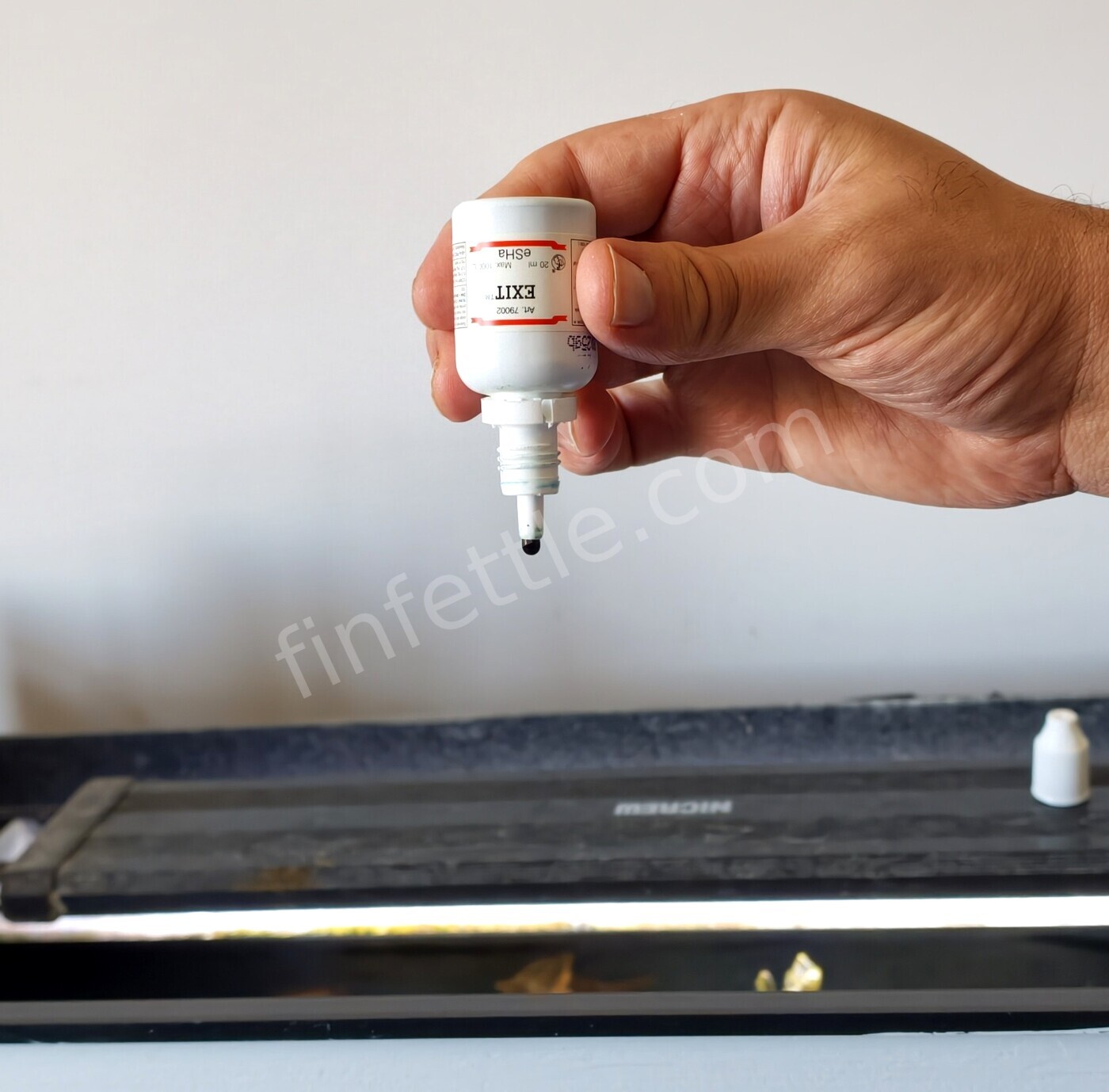 Dosing eSHa EXIT anti-whitespot treatment into an aquarium with a pipette